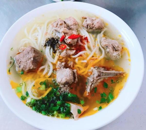 Tàu QB1 đưa bạn đến Đồng Hới lúc bình minh vừa hé, kịp ghé quán nhỏ bên ga thưởng thức một bát cháo canh nóng hổi, đậm đà vị quê.